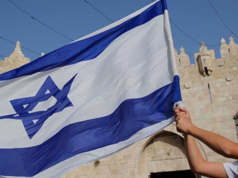 Un ragazzo sventola la bandiera di Israele a Gerusalemme (foto LaPresse)