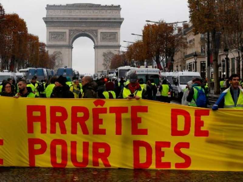 I gillet gialli protestano a Parigi. "Macron smettila di prenderci per i fondelli", la scritta sullo striscione (Foto LaPresse)