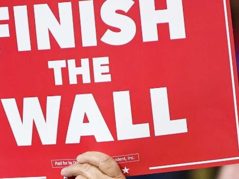 Un sostenitore di Trump espone il manifesto: "Costruite il muro" (Foto LaPresse)