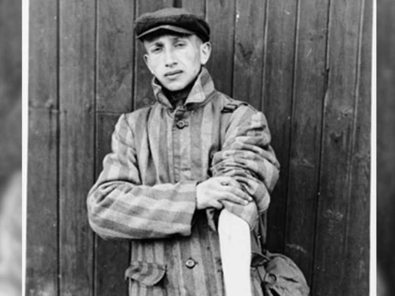 Un sopravvissuto del campo di concentramento di Buchenwald mostra il braccio tatuato (via Wikimedia per gentile concessione di Stanley Moroknek. Museo memoriale dell'Olocausto degli Stati Uniti)