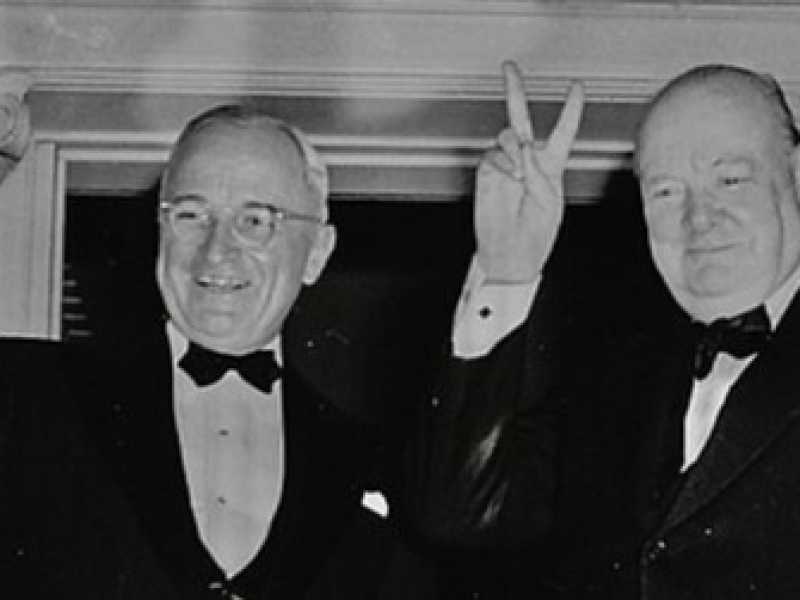 Winston Churchill che fa il segno della "Vittoria" e il presidente Truman fuori da Blair House a Washington (via Wikimedia)