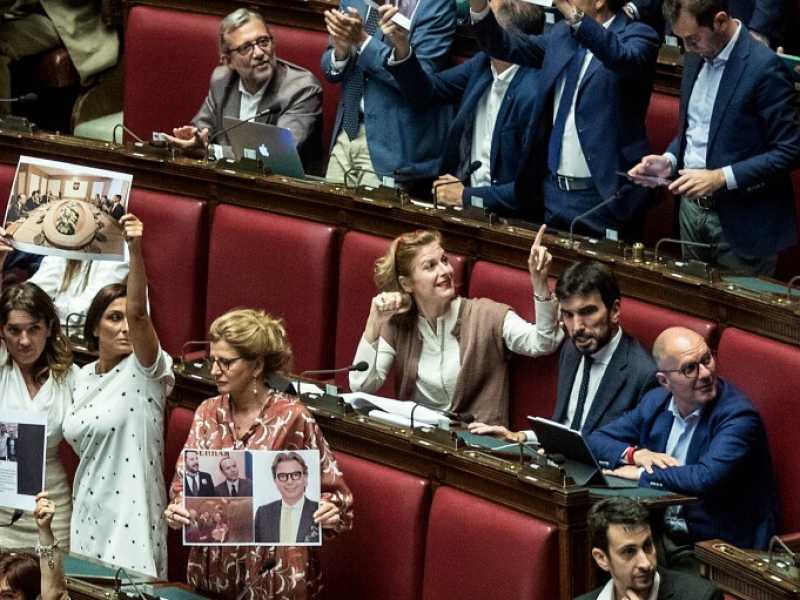 I deputati del Pd alla Camera mostrano le foto dei personaggi coinvolti nell'inchiesta sui presunti fondi russi alla Lega (Foto LaPresse)