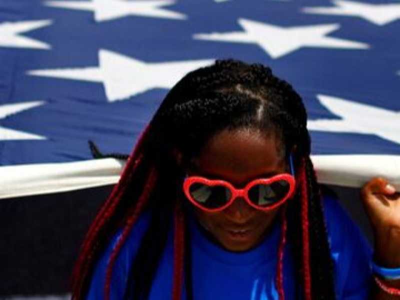 Una ragazza porta una bandiera americana durante la parata del 4 luglio dell'anno scorso a Washington (foto Reuters)