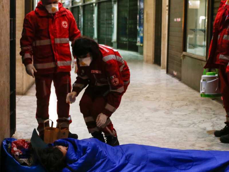 Volontari della Croce Rossa portano cibo e disinfettanti ai senzatetto di Roma (foto LaPresse)