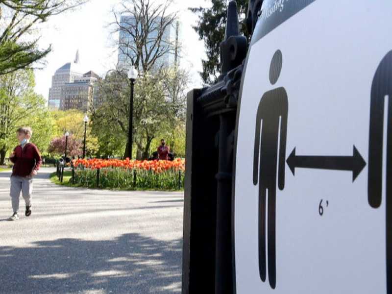 Segnaletica che ricorda la distanza minima da tenere tra le persone in un parco a Boston (foto LaPresse)