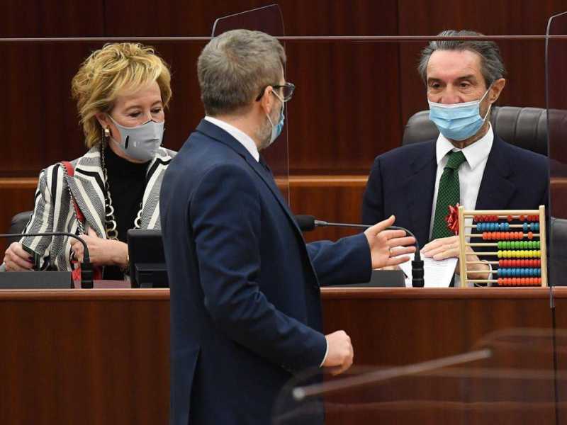 Il consigliere del Pd Pietro Bussolati consegna polemicamente un pallottoliere ad Attilio Fontana. In foto anche Letizia Moratti (Ansa)&nbsp;<br />