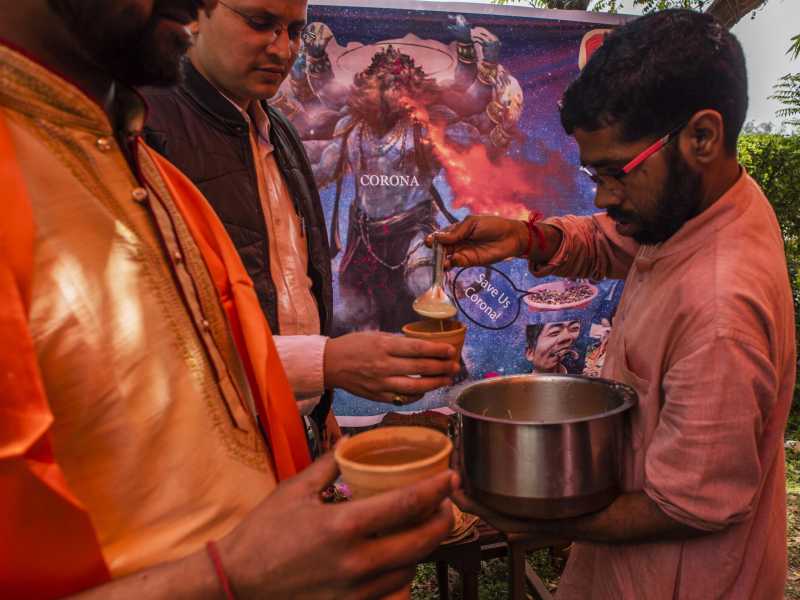 Un membro di un'organizzazione ind&ugrave; distribuisce panchagavya, una miscela rituale fatta di sterco di vacca e latte (foto di Yawar Nazir / Getty Images)&nbsp;<br />