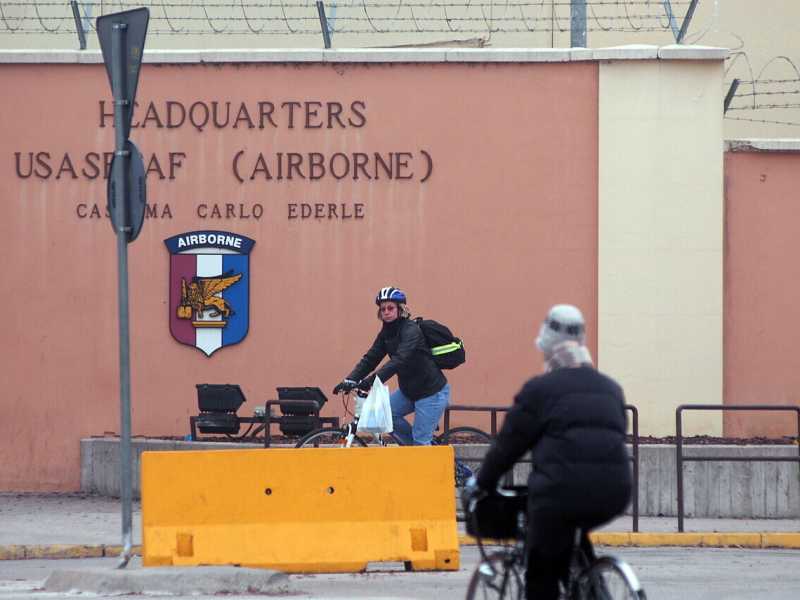 In bicicletta di fronte all'ingresso della Caserma Carlo Ederle in viale della Pace a Vicenza (Ansa, Andrea Merola)&nbsp;<br />