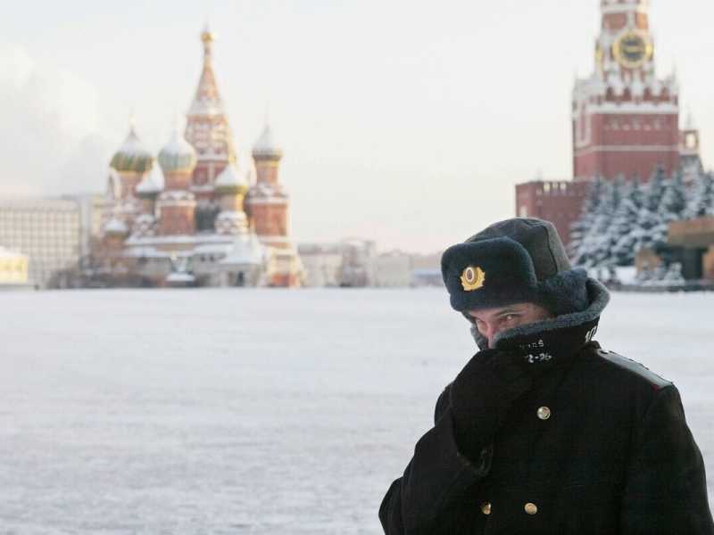 MOSCOW - JANUARY 7: A Russian police officer, braving the bitter cold, patrols Red Square with the Kremlin in the background January 7, 2003 in Moscow&nbsp;<br />