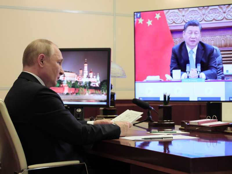 Il presidente russo Vladimir Putin e, nello schermo, quello cinese Xi Jinping (LaPresse)