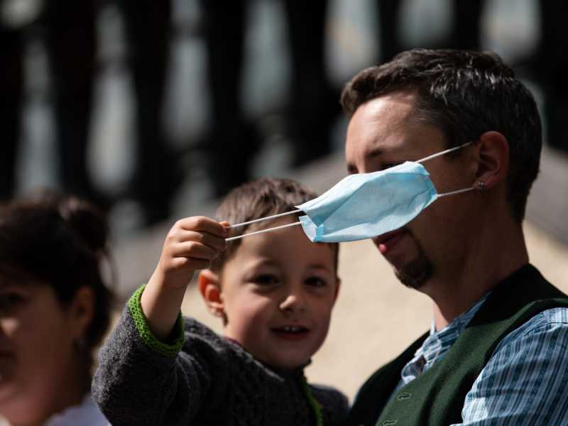 Un figlio sfila la mascherina a suo papà (Getty Images)