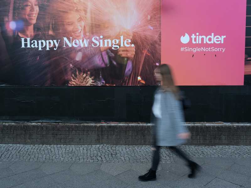 Una donna passa vicino a una pubblicit&agrave; di Tinder a Berlino, Germania (Getty Images)