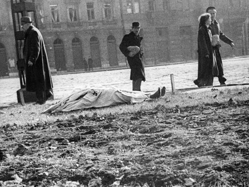 Budapest, invasione sovietica del 1956. Dopo ore di coda per il pane, i cittadini rientrano a casa. Per terra resta un cadavere (LaPresse)<br />