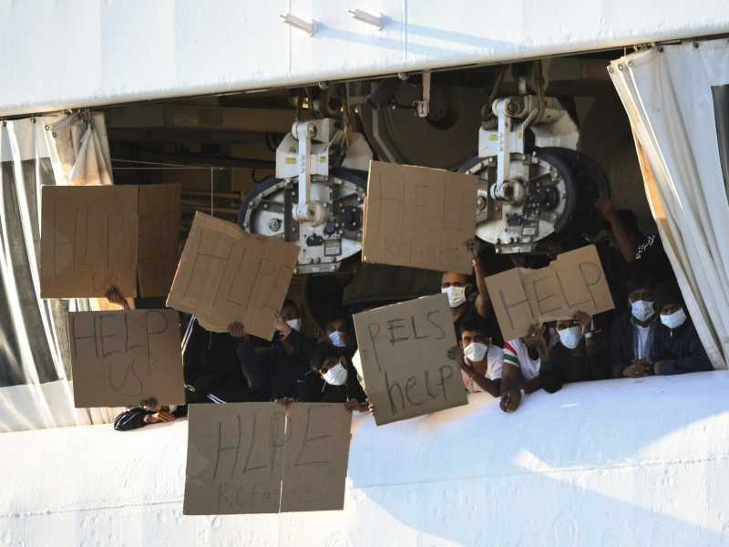Migranti della Ocean Viking mostrano cartelli con richieste di aiuto (foto LaPresse)