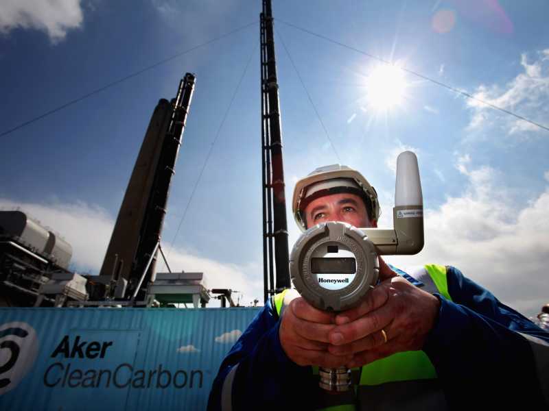 Uno scienziato con un monitor di pressione, accanto a una nuova unità di test per la cattura del carbonio in Scozia (Foto di Jeff J Mitchell/Getty Images) <br />