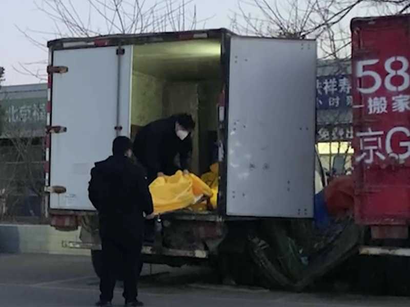 Lavoratori caricano sacchi per i cadaveri su un camion in un complesso funerario a Pechino, venerd&igrave; 16 dicembre 2022 (AP Photo/Dake Kang)&nbsp;<br />