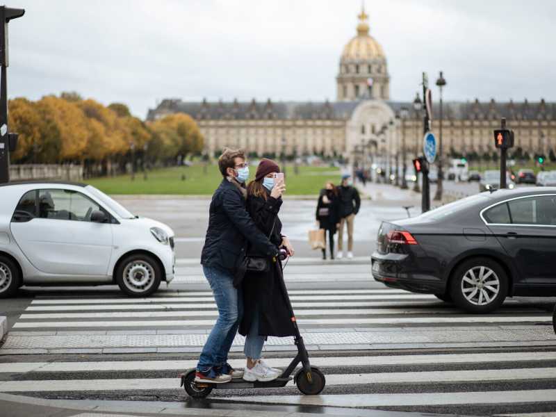 Una coppia in monopattino si scatta una foto davanti all&rsquo;Hotel des Invalides (AP Photo/Lewis Joly)&nbsp;<br />