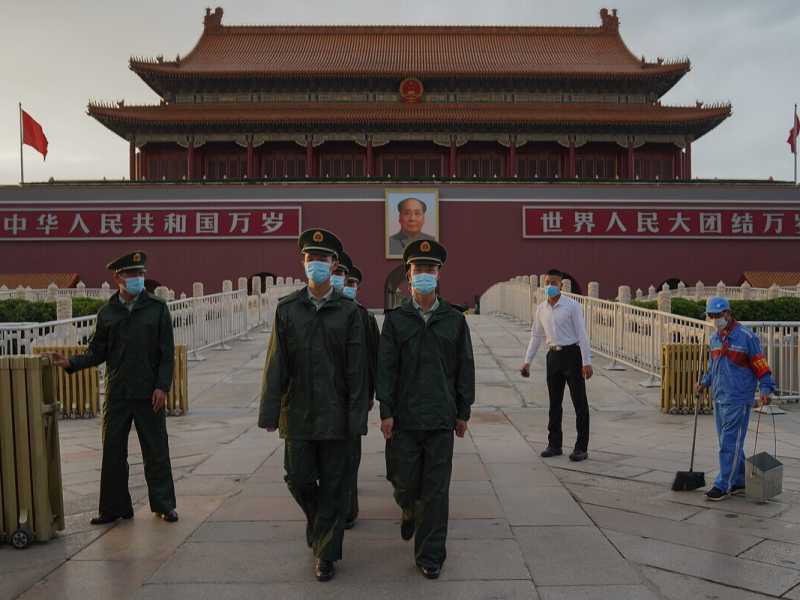 Due agenti cinesi marciano attraverso la porta di Tiananmen (Foto di Lintao Zhang/Getty Images)&nbsp;<br />