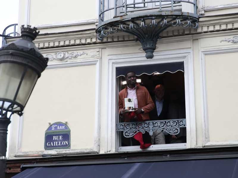 Il senegalese Mohamed Mbougar Sarr al balcone del ristorante Drouant subito dopo aver vinto il premio Goncourt edizione 2021 (foto LaPresse) <br />