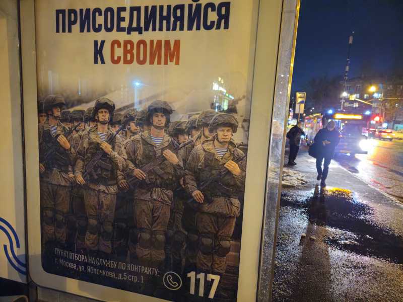 Mosca, manifesto che pubblicizza il servizio a contratto nelle forze armate russe, alla fermata dell'autobus (Getty Images) <br />