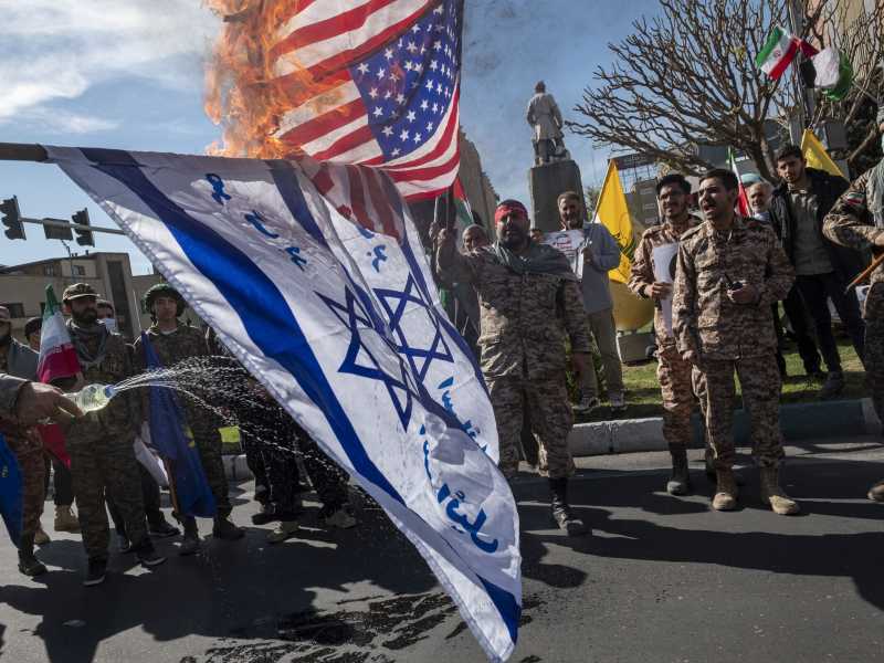 Guardie della Rivoluzione bruciano bandiere di Israele e degli Stati Uniti a Teheran, Iran, nell'aprile 2024 (Morteza Nikoubazl/Getty Images) <br />