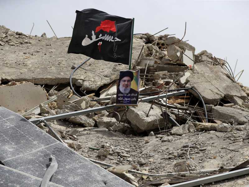 Una foto del leader di Hezbollah Hassan Nasrallah tra le macerie di un edificio distrutto da un attacco israeliano nel sud del Liban (AP/Mohammad Zaatari) <br />