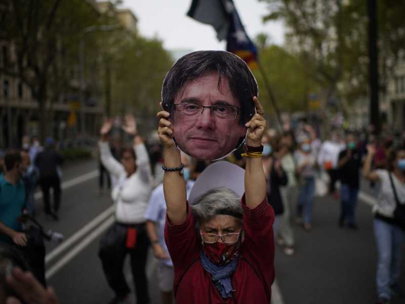 Barcellona, una donna regge un manifesto con il volto dell'ex leader catalano Carles Puigdemont (AP Photo/Joan Mateu, file) <br />