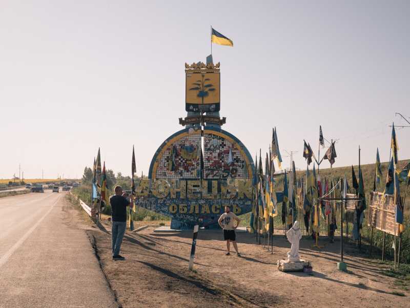 Uomini si fermano davanti a un cartello che segnala l'ingresso all'area di Donetsk, parte della regione ucraina del Donbas. <br /><br />Credits: Alice Martins per il Washington Post