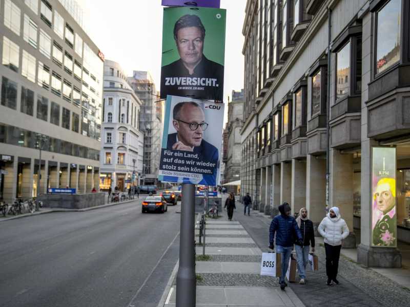 Manifesti della campagna elettorale di Robert Habeck (Verdi), in alto, e Friedrich Merz (CDU) a Berlino (AP Photo/Ebrahim Noroozi)&nbsp;<br />
