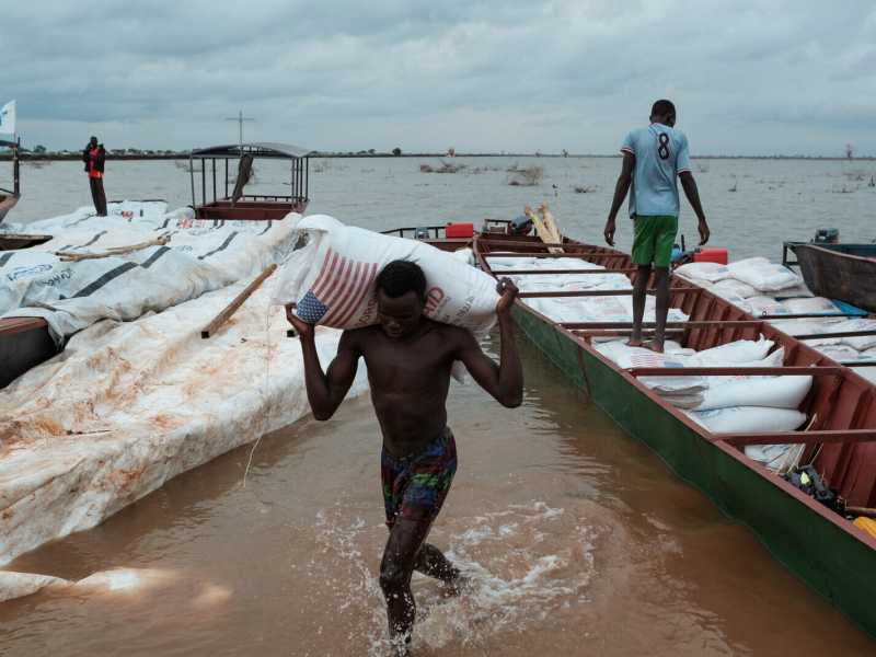 Luglio 2023, un giovane trasporta un sacco di sorgo dell'USAID in un campo per sfollati a Bentiu, nel Sudan del Sud (GettyImages) <br />