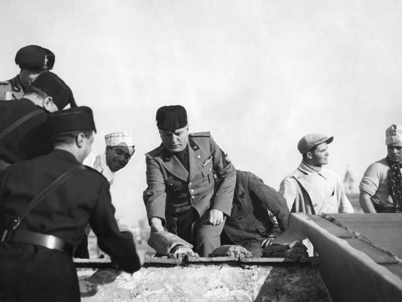 Benito Mussolini posa una piastrella all'inizio della costruzione di un nuovo edificio a Roma, il 19 febbraio 1935 (Gamma-Rapho via Getty Images) <br />