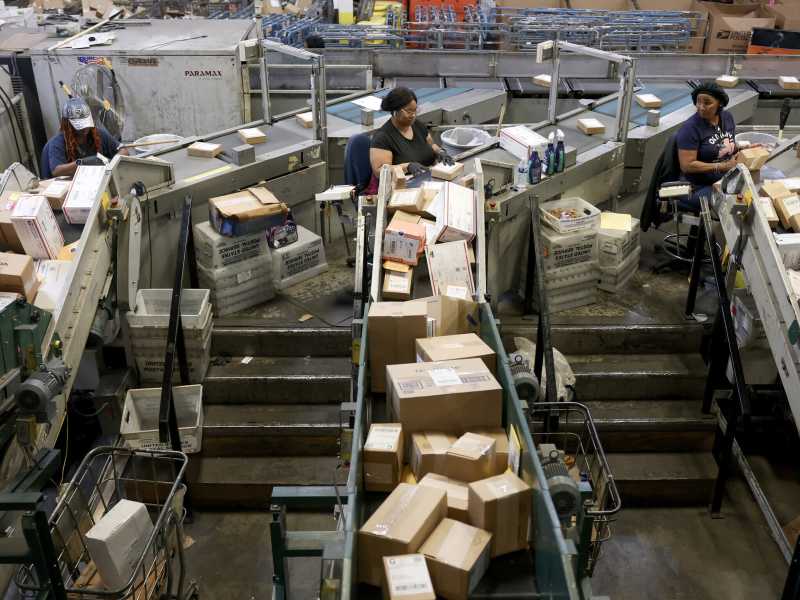 Addetti del servizio postale statunitense smistano i pacchi al Royal Palm Processing and Distribution Center di Opa Locka, Florida (Joe Raedle/Getty) <br />