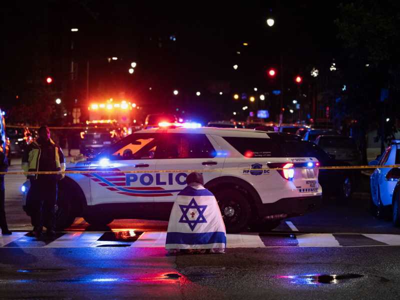 Un passante prega indossando una bandiera israeliana con una croce al centro, vicino al Capital Jewish Museum (Foto di Tom Brenner per il Washington Post - Getty Images)<br />