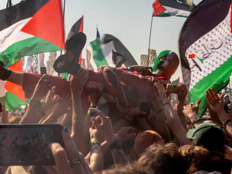 &nbsp;DJ Prova&iacute; del trio hip hop irlandese Kneecap al festival di Glastonbury fra bandiere della Palestina (foto Getty)<br />