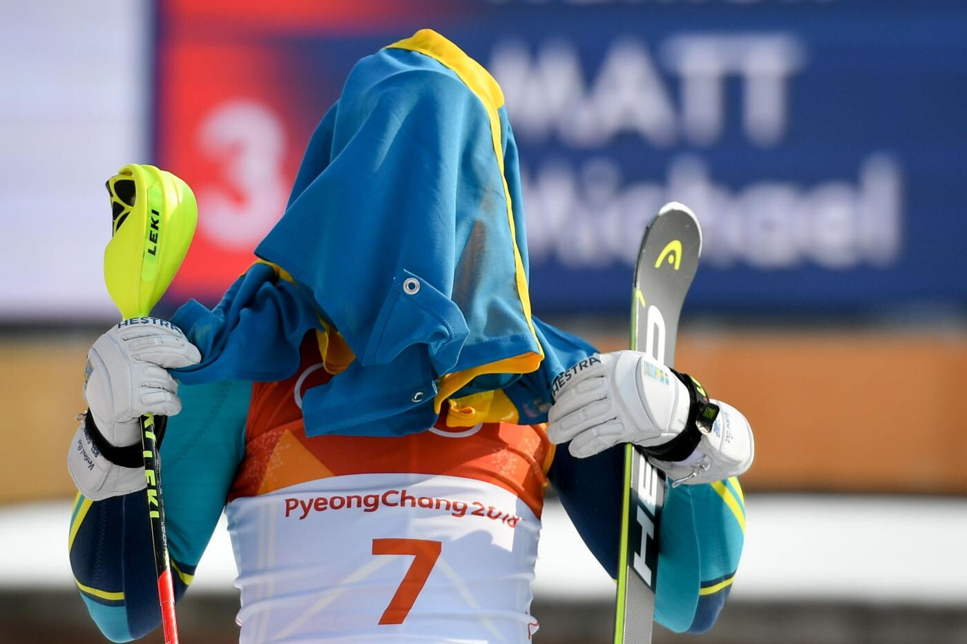 La Medaglia d'oro svedese Andre Myhrer si copre la faccia con la bandiera mentre celebra sul podio durante la cerimonia della vittoria per lo Slalom