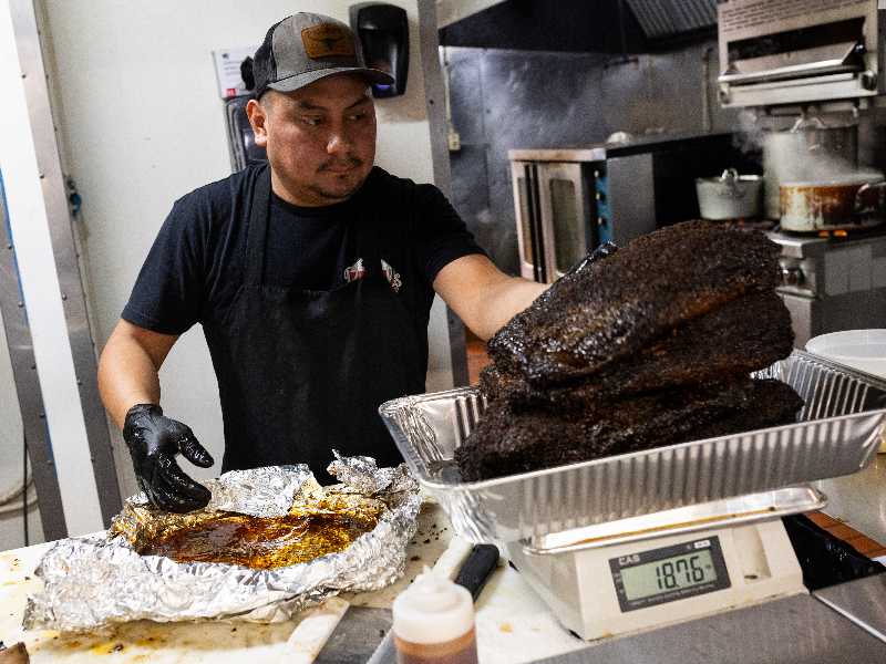 Un ristoratore affetta del petto di manzo (brisket) in un locale a Houston, Texas
