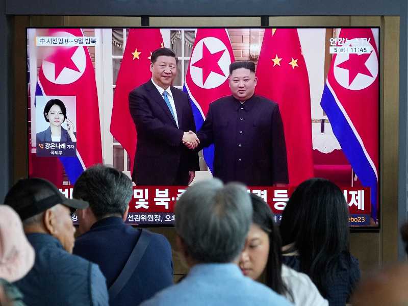 Seul, 5 giugno 2026. Viaggiatori alla stazione ferroviaria della capitale sudcoreana osservano un notiziario che mostra un’immagine d’archivio del leader nordcoreano Kim Jong Un e del presidente cinese Xi Jinping